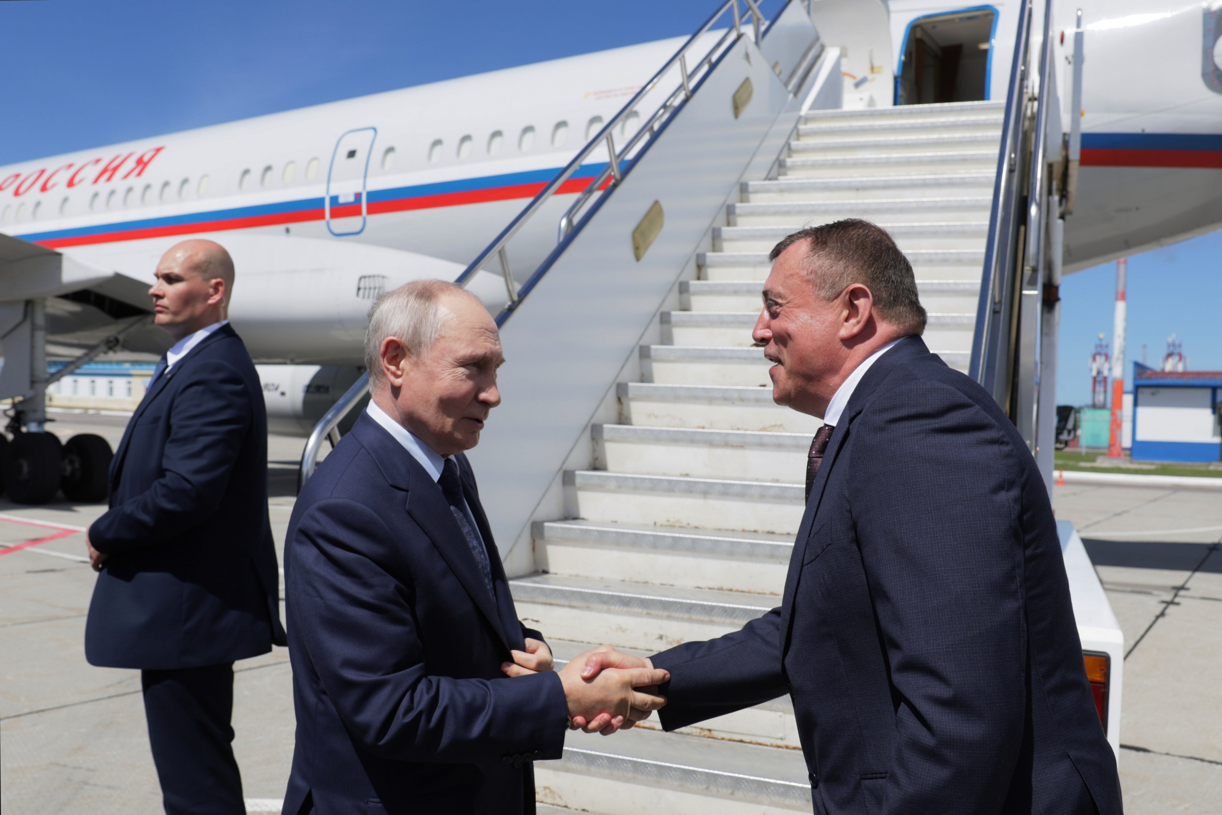 Russian President Vladimir Putin shakes hands with Sakhalin Region Governor Valery Limarenko (right) at an airport on Iturup Island, the largest of the Kuril Islands, last Thursday. Photo: Sputnik/Kremlin/AP