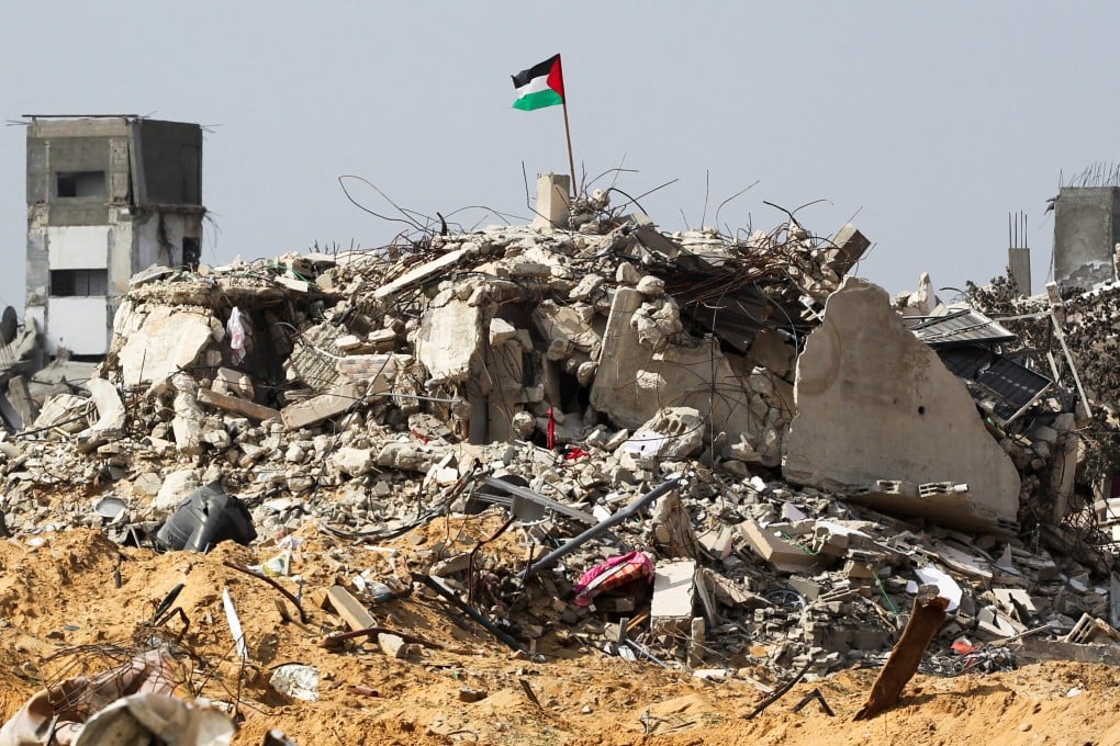 A Palestinian flag flutters among the rubble of buildings in Rafah, the southern Gaza Strip, on Tuesday. Photo: Reuters