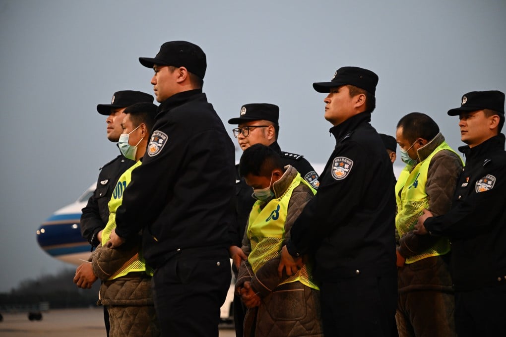 Chinese police escort Chinese nationals suspected of being involved in telecoms fraud after they were repatriated from Myanmar, in Nanjing on February 20. Photo: Xinhua