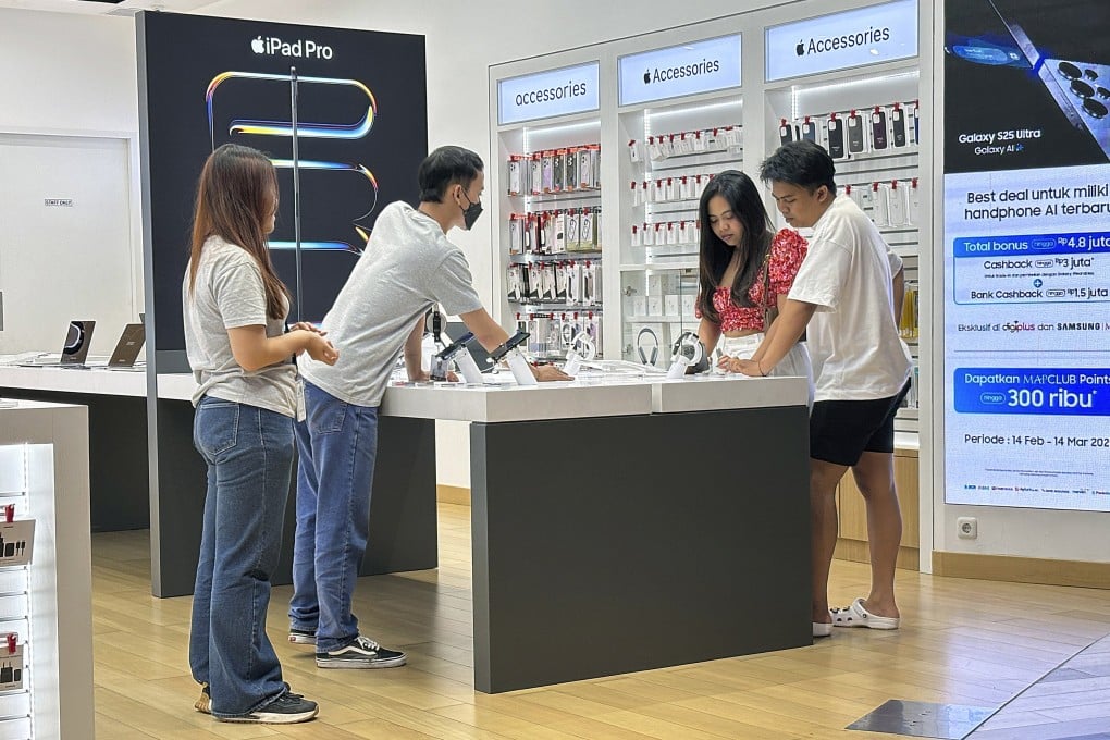 Customers inspect Apple iPhones at a shopping centre in Bali in February. Indonesia has secured a US$300 million investment from Apple, reopening the door for iPhone 16 sales in the country. Photo: EPA-EFE