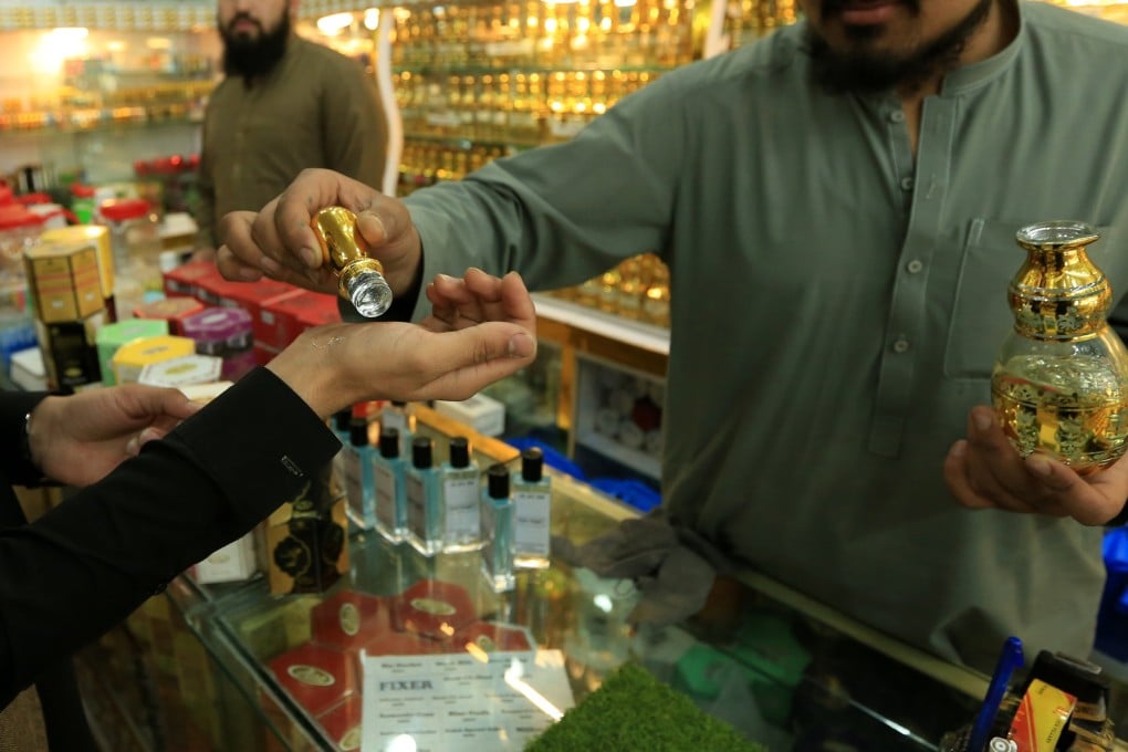 A customer tries on non-alcoholic perfumes at a shop in Peshawar, Pakistan, earlier this month. Photo: EPA-EFE