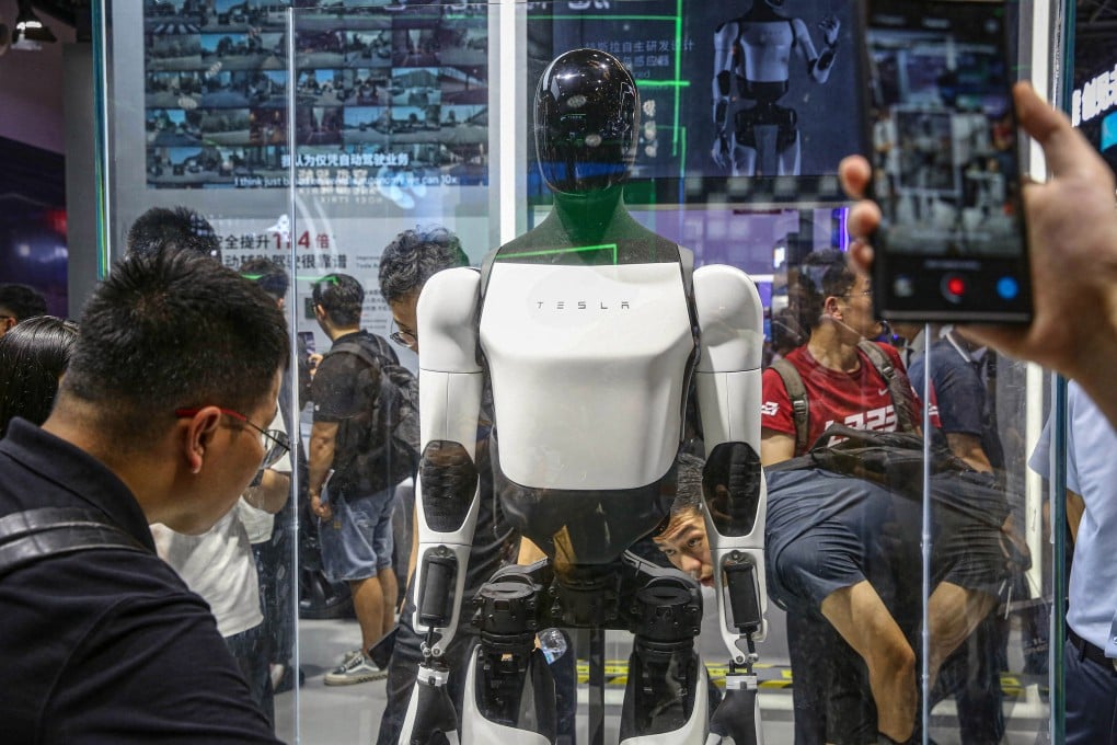 Visitors look at Tesla’s humanoid robot Optimus at its exhibition booth during the World Artificial Intelligence Conference in Shanghai on July 5, 2024. Photo: AFP