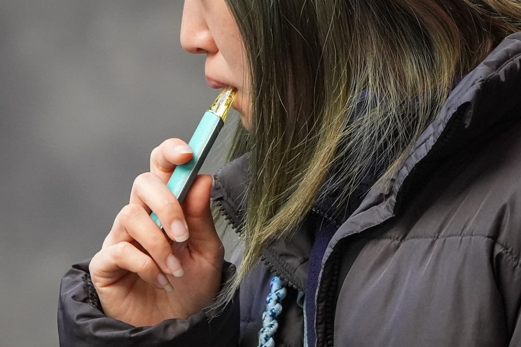 A woman smokes an e-cigarette in Mong Kok. Hong Kong is set to ban possession and smoking of e-cigarettes in public from April of next year. Photo: Eugene Lee