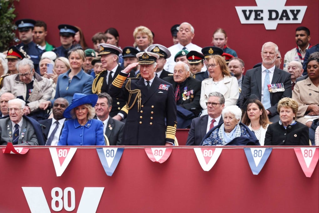 King Charles salutes during an armed forces procession to celebrate the 80th anniversary of VE Day, in London on Monday. Queen Camilla is seated left and UK Prime Minister Keir Starmer on the right. Photo: AFP