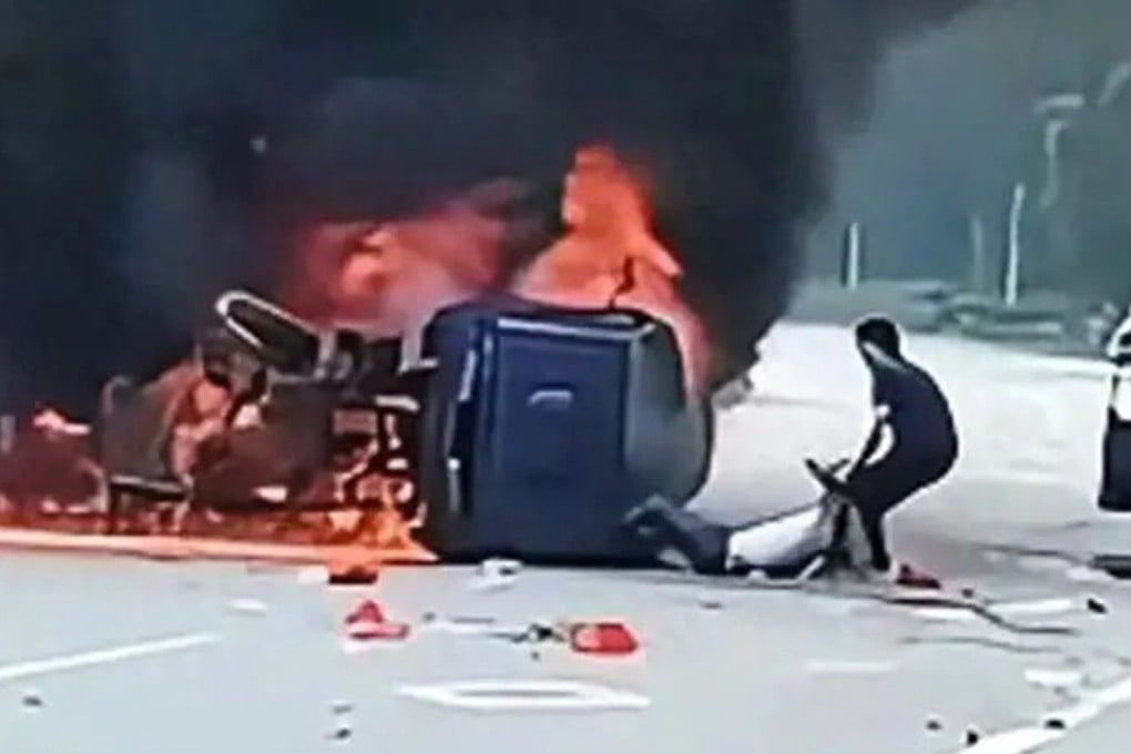 A brave Chinese man forced open the door of a blazing car with his bare hands to save its injured driver moments before the vehicle exploded. Photo: Sohu