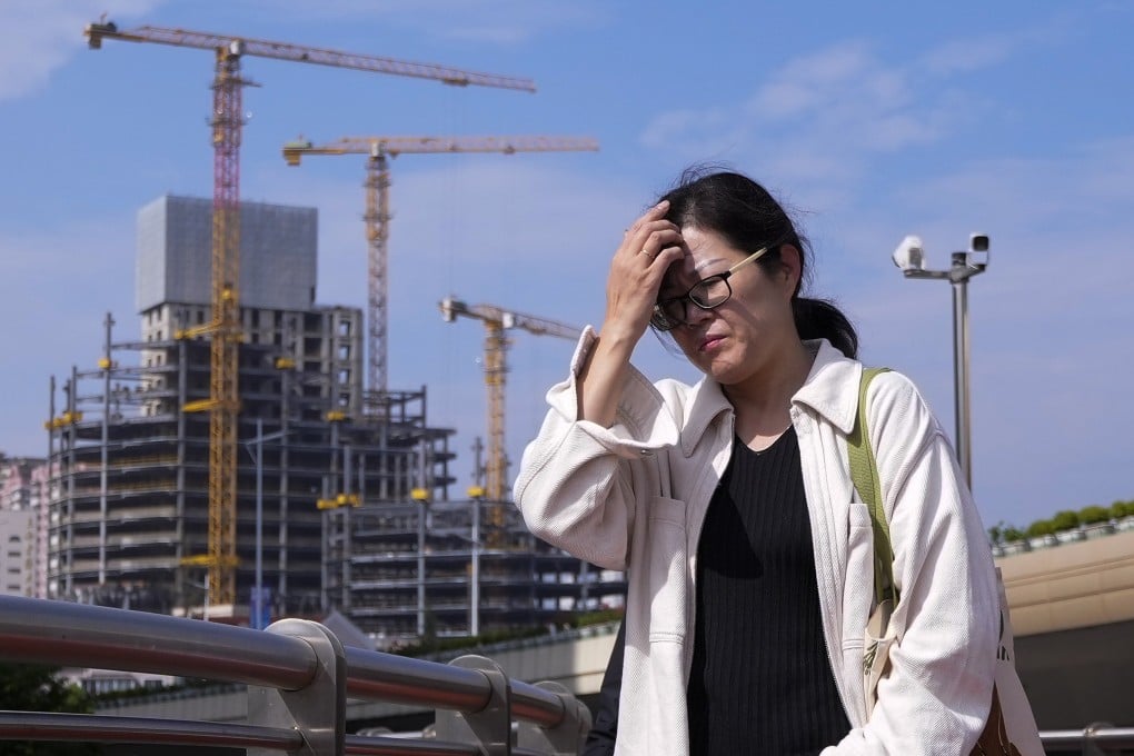 A woman passes a construction project in Shanghai. Photo: AP