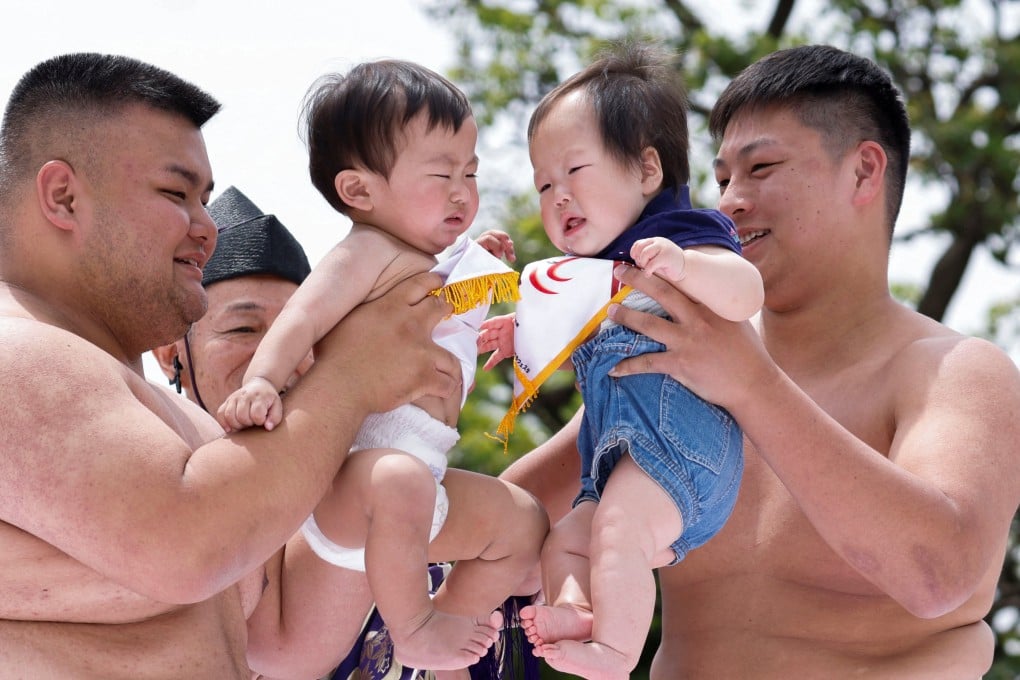 Amateur sumo wrestlers hold babies during the Nakizumo Crying Baby Festival at a temple in Tokyo, Japan, last month. Photo: Reuters