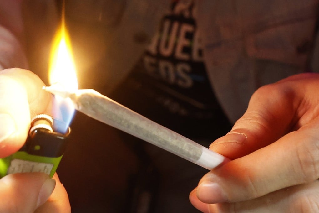 A customer lights a joint at a cannabis smoking lounge in Thailand. Photo: EPA-EFE