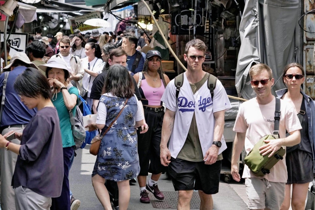Foreign tourists walk in Tokyo’s Tsukiji area on May 21. Photo: Kyodo