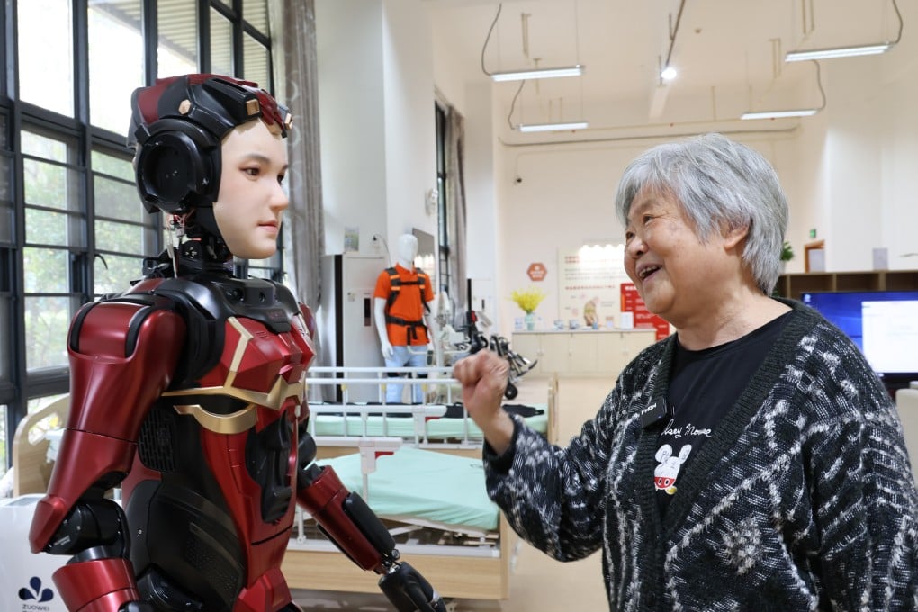 A senior resident at a nursing home in Shenzhen interacts with a humanoid robot. Photo: Xinhua