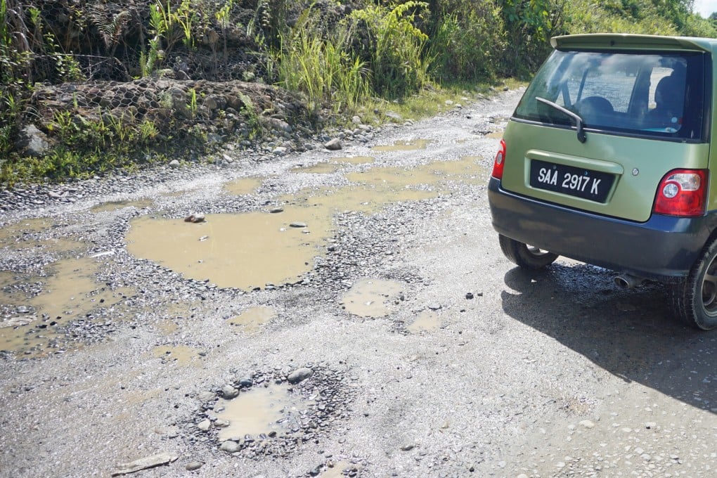 Muddy potholes in middle of a road in rural Sabah, Malaysia. Photo: Shutterstock