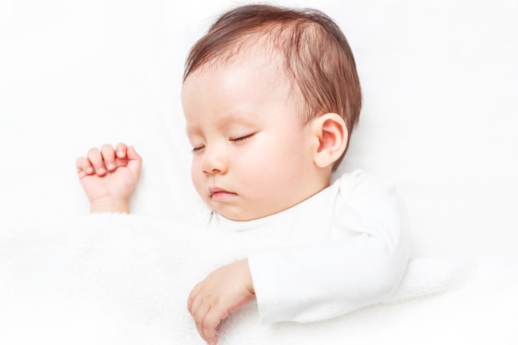 An infant asleep on the bed. A three-month-old baby in Malaysia died after being suffocated by his dead father’s body. Photo: Shutterstock