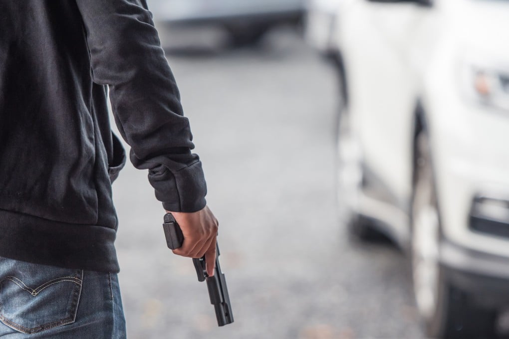 A man holds a gun in car park. A series of gun attacks in the past few weeks have made Malaysians jittery. Photo: Shutterstock