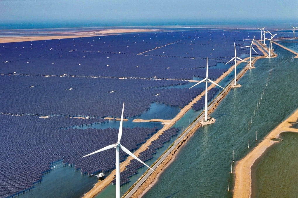 Solar panels and wind turbines are seen at a new energy power generation project in the city of Binzhou in Shandong province, China on June 11. Photo: AFP