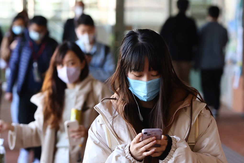 A student checks her phone as she walks through the campus of the University of Hong Kong in 2022. Photo: Dickson Lee