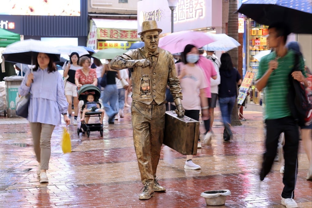 A performer braves the rain on a street in Causeway Bay last month. Photo: Nora Tam