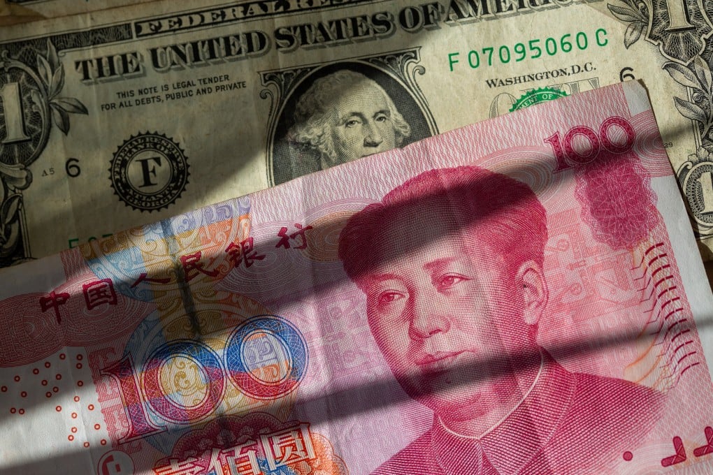 Chinese yuan banknotes are sandwiched between several US dollar bills. Photo: Fernando Gutierrez-Juarez/dpa