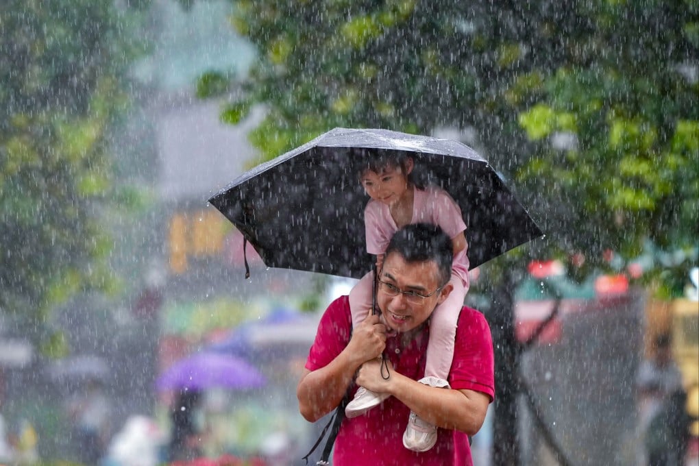 Hong Kong residents brave the heavy rain in Shek Mun, Sha Tin district, on Saturday morning. Photo: Sam Tsang