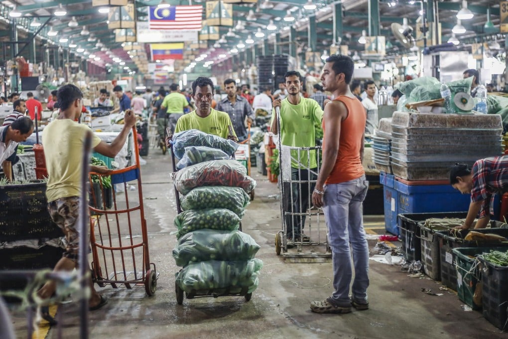 Foreign workers from Bangladesh and Myanmar at a market in Kuala Lumpur. Malaysia will cut the proportion of migrant workers to 10 per cent of the total workforce from 2026. Photo: Shutterstock