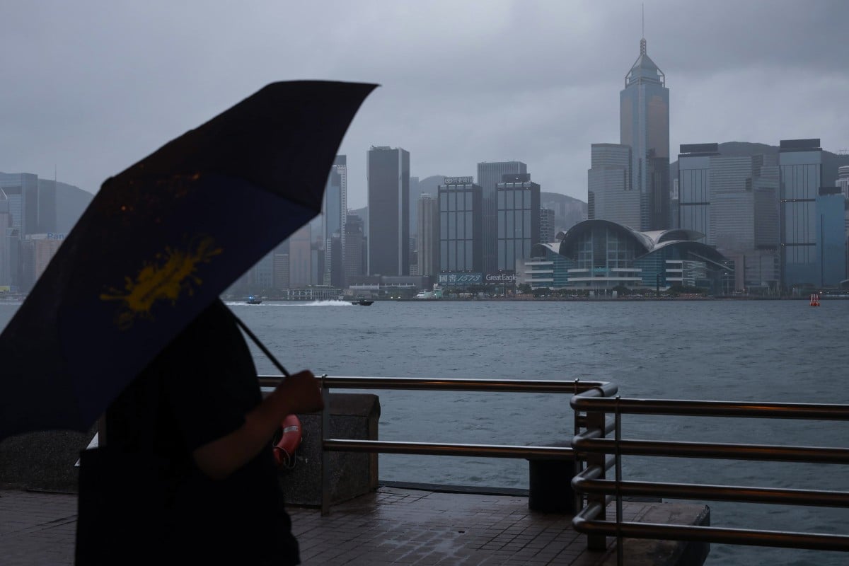 A person takes cover under an umbrella in Tsim Sha Tsui, with the No 9 typhoon signal in effect. Photo: Edmond So