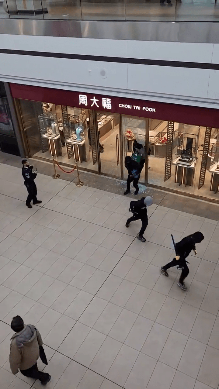 閉路電視畫面顯示,周大福被劫後6名劫匪逃離時,商場保安在門外持手機拍攝不阻止。