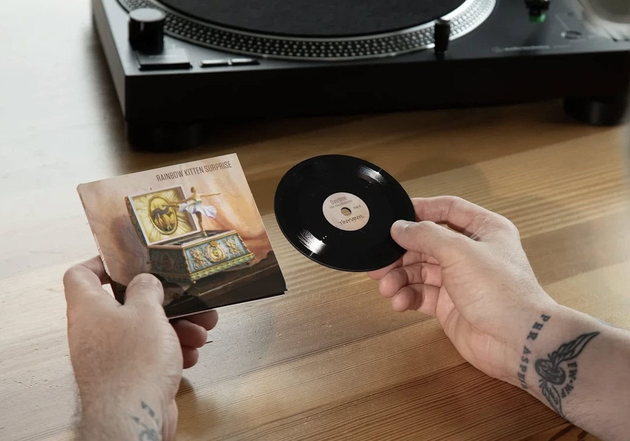 a person holding a tiny vinyl