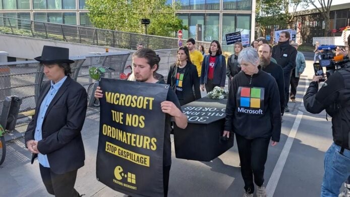抗議者手持標語反對Windows 10停止更新,擔心3億台電腦成電子垃圾,呼籲環保與數碼可持續發展。.
