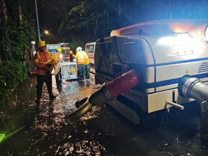 道路清理與排水作業現場,工程人員在雨中操.