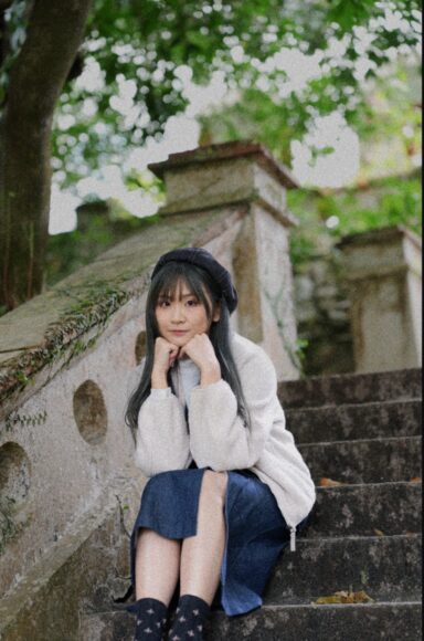 青春少女在戶外石階上休憩,穿著白色毛衣和.