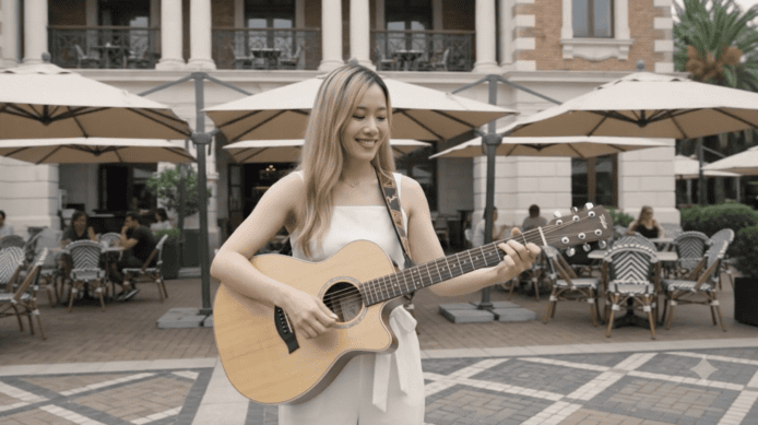 戶外街頭音樂表演,年輕女子彈奏吉他,享受.