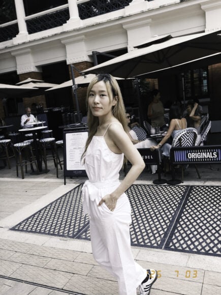 時尚女性在戶外咖啡店享受陽光,穿著白色休.