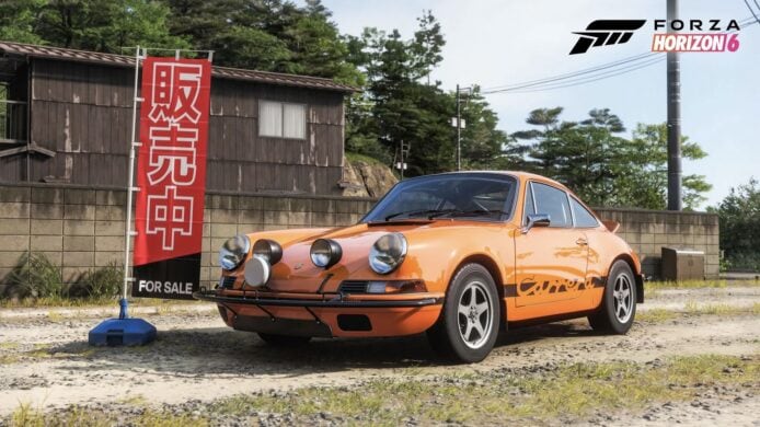 經典橙色保時捷911在戶外展示,旁邊有銷售標誌,背景為木屋和樹木,彰顯遊戲中的經典車輛和自然場景。.