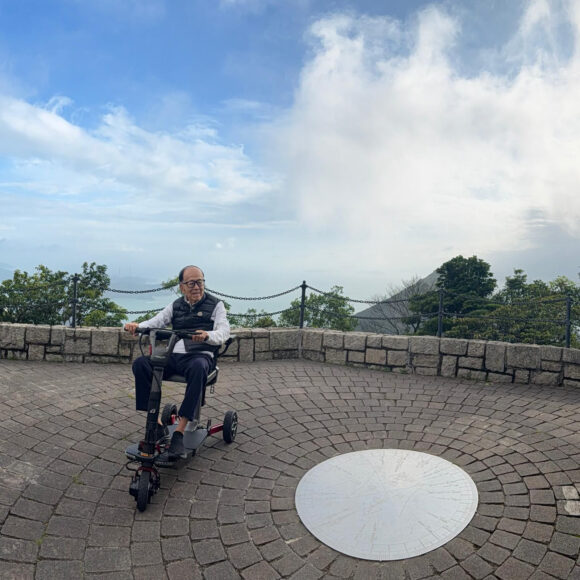 行人在山頂觀景台騎著電動車,背景是壯麗的.