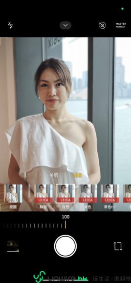 女性在窗邊拍照，展現時尚與自信.