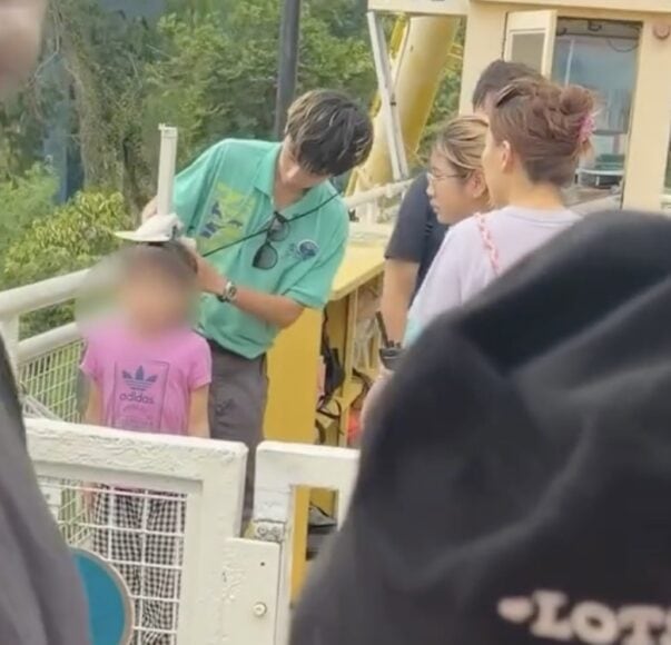 家長與小孩在海盜船前交談.