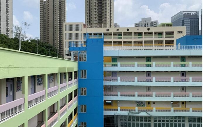 學校外觀，彩色校舍與高樓背景，展示香港城.
