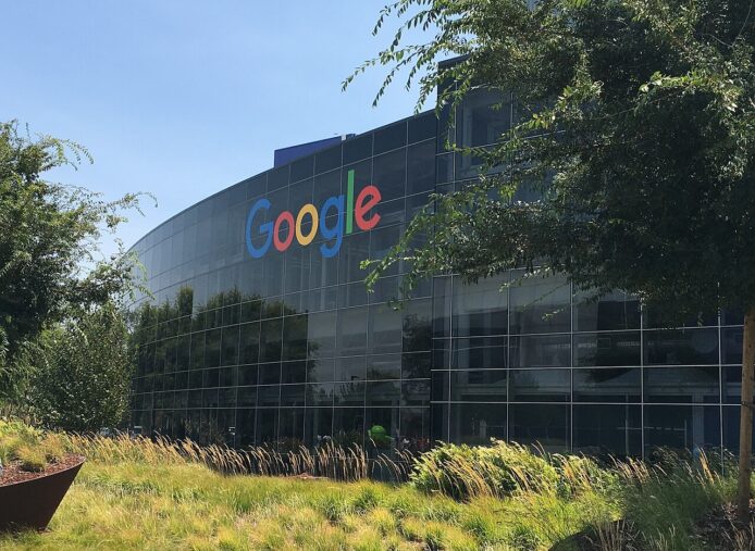 Google總部大樓外觀，玻璃幕牆反映藍天與綠色.