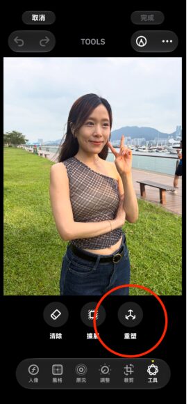 女性在戶外海濱公園拍照,背景有海景和遊艇.
