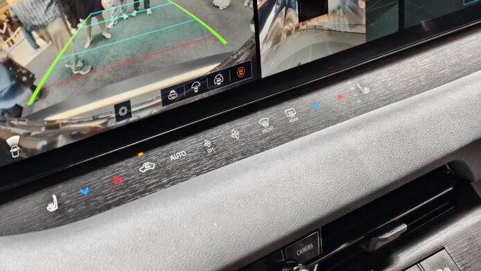 車內多功能顯示屏與控制面板，展示車輛後視.