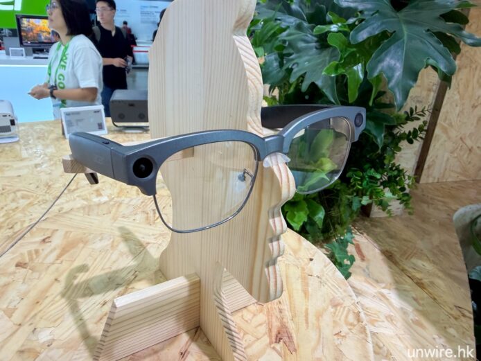 智慧眼鏡展示於展台上,背景為綠色植物和展.
