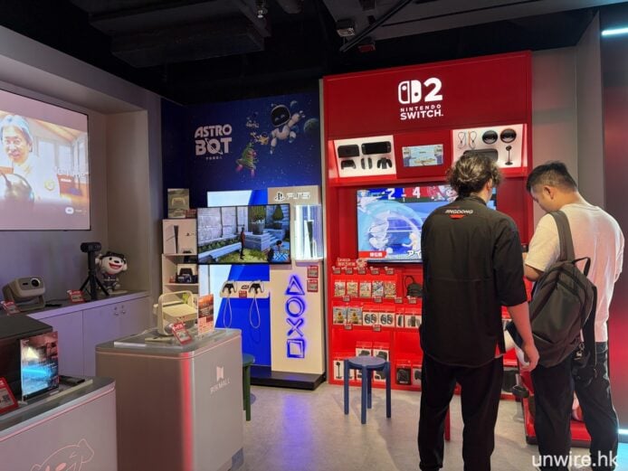 顧客在電子產品展示區選購遊戲設備.