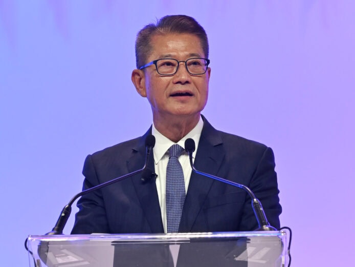 ALT:科技領袖在會議上發言,背景為藍色光影.