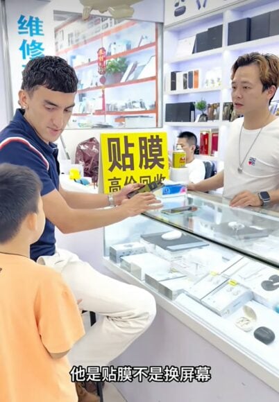 年輕店員與顧客討論手機修理.