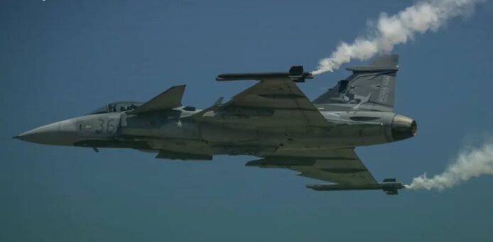 空中飛行的戰鬥機，留有煙霧軌跡.