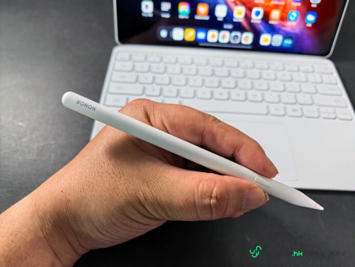 手持 Honor MagicPad4 在筆記本前.