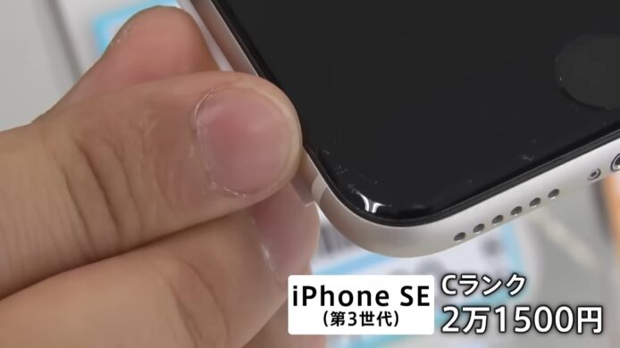 手持二手iPhone SE手機,顯示花痕.