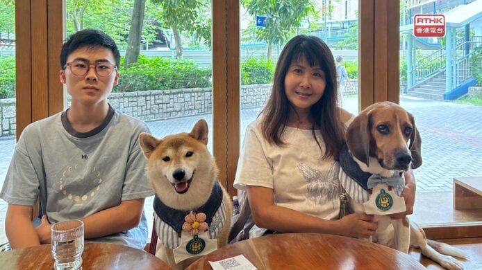 一對男女與兩隻狗在餐廳內合照.