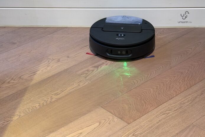 Dyson Spot+Scrub AI掃地機在木地板上工作.