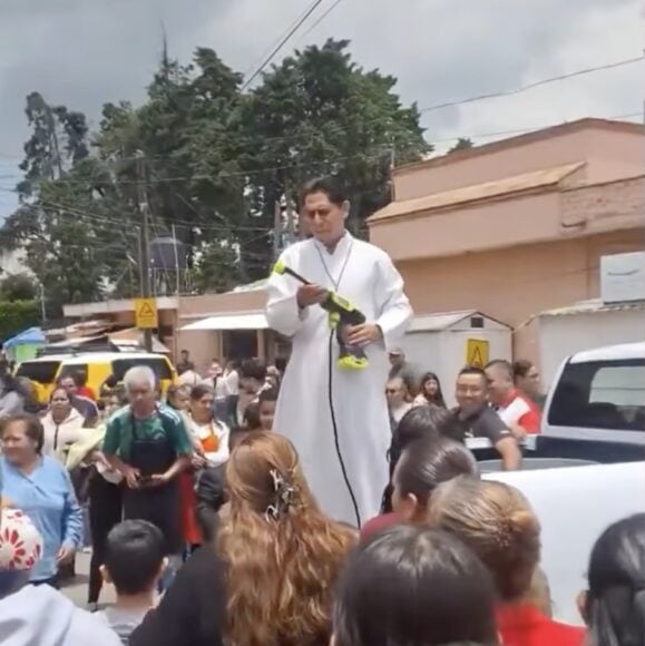 神父用高壓水槍為人祈福.