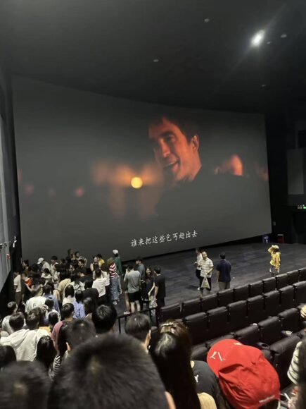 戲院中大屏幕播放電影場景.